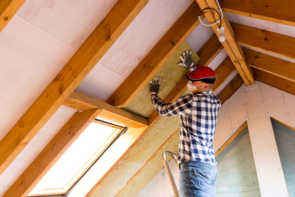 Étudiant en Immobilier et Rénovation Énergétique posant de l’isolation.